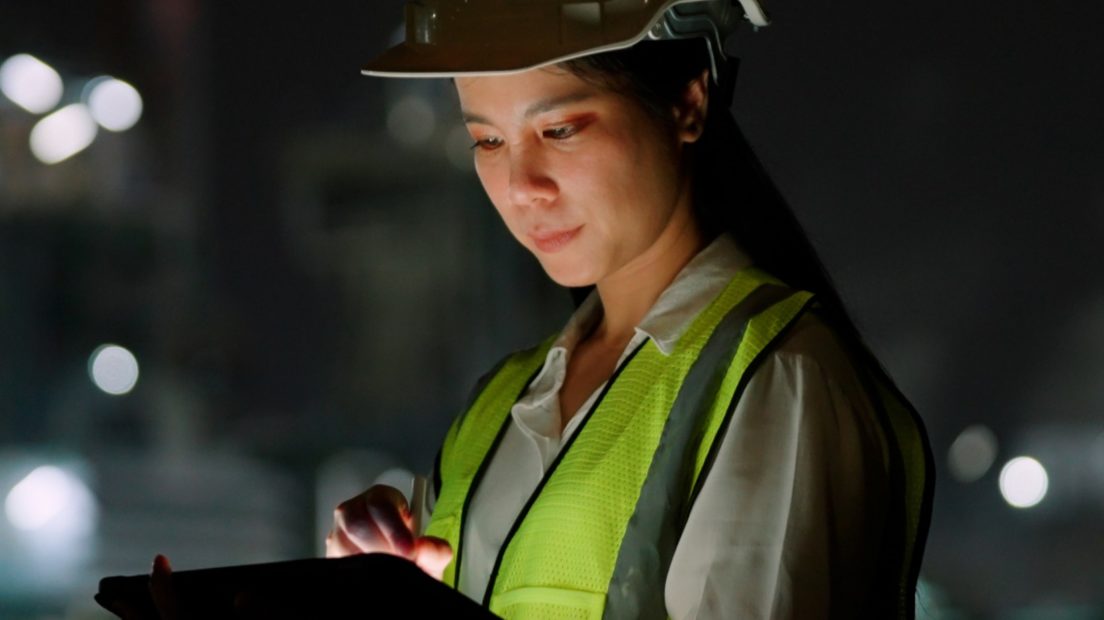 Engineer working on tablet at night