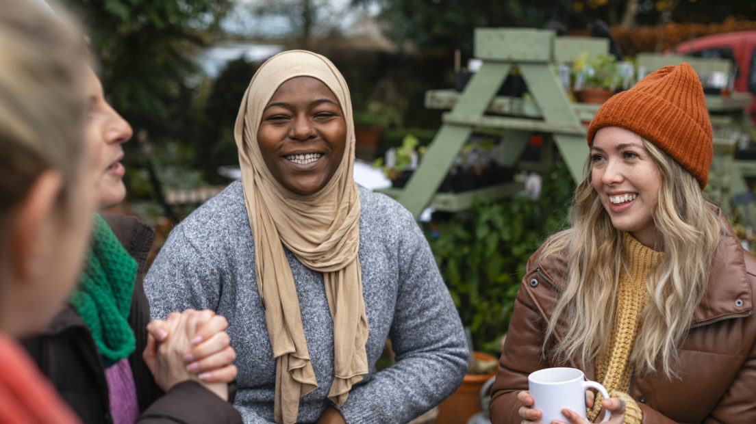 A group of women from different backgrounds laughing together