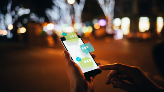 User dialogue with AI chat bot on futuristic smartphone interface, while walking along the city street, close-up